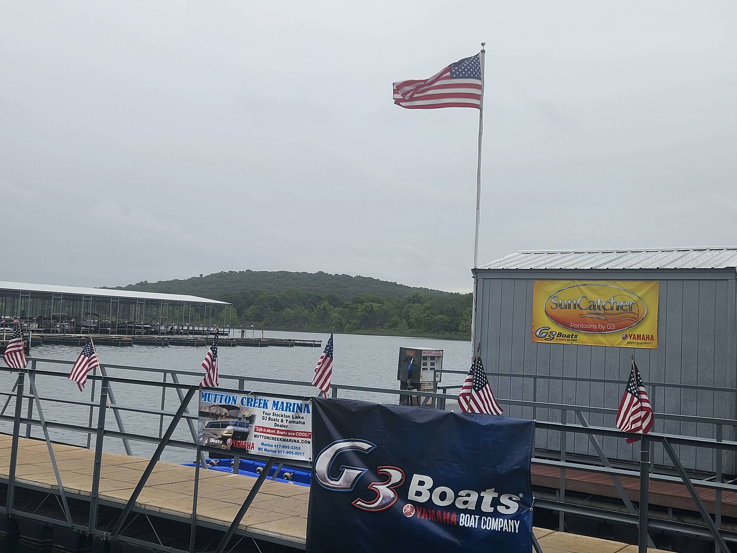 Marina dock with a G3 Boats flag flying over the lake