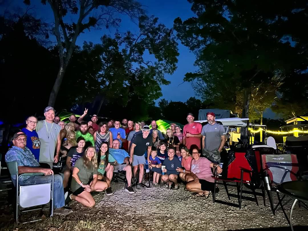 A large group gathered outdoors at night for a marina event