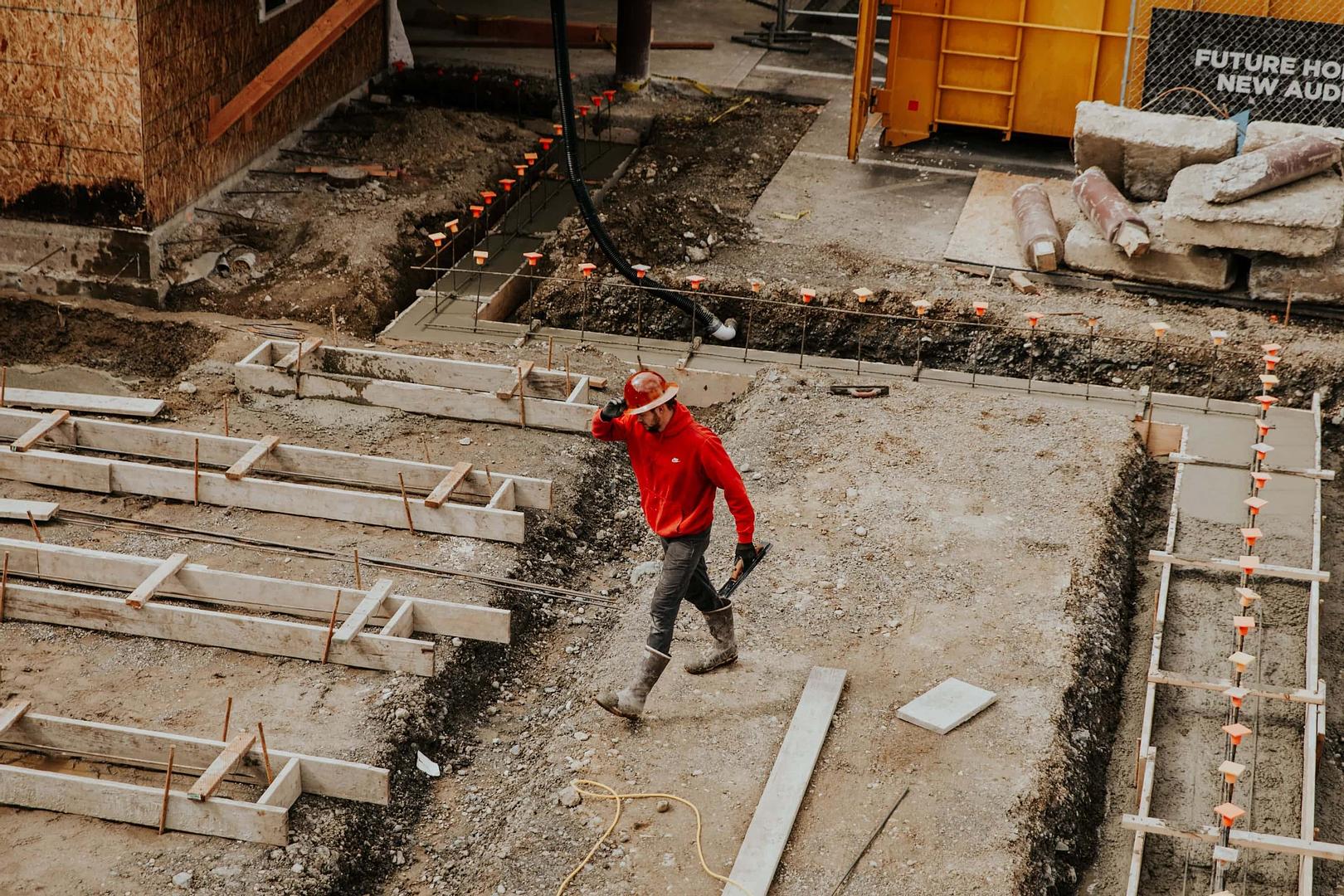 Construction worker walking across a power plant job site.