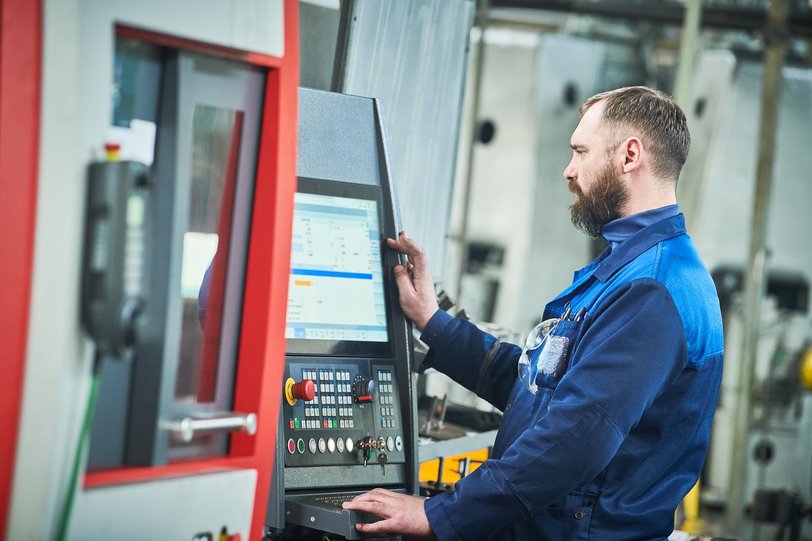 Technician working at a CNC machine control