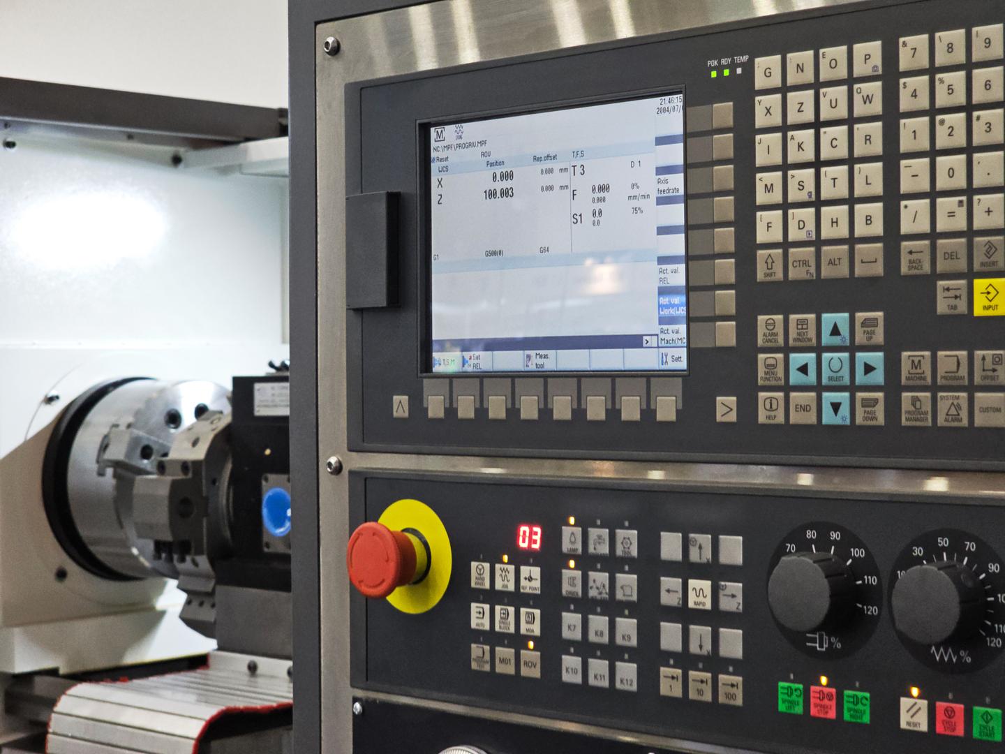 Machine control panel next to a lathe chuck