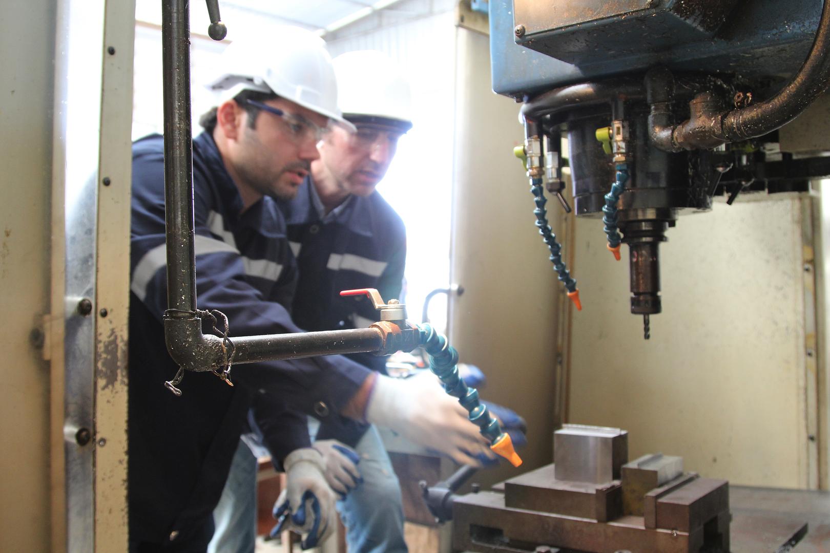 Two technicians working on a machine together