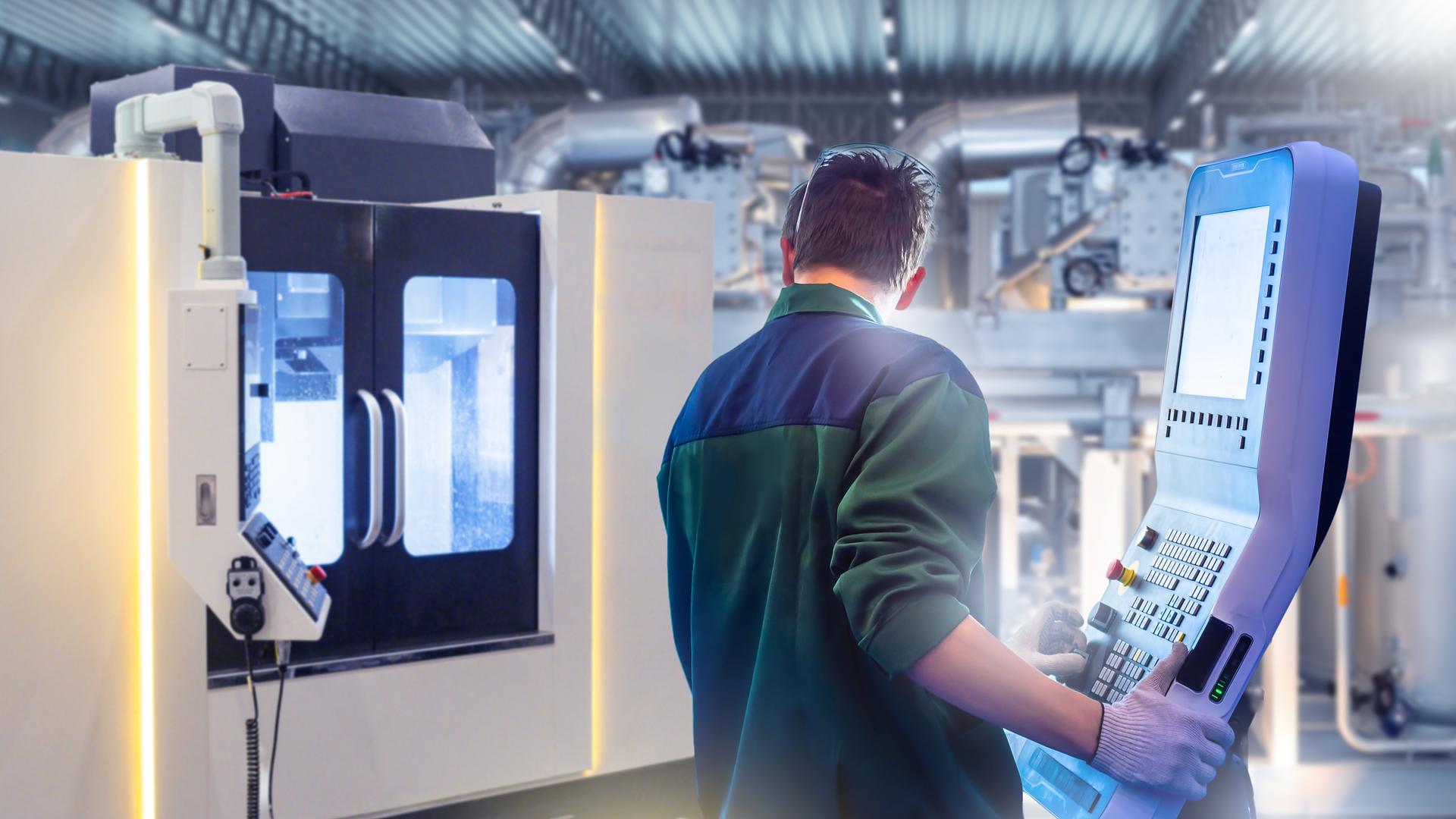 Machinist working at the control panel of a CNC machine
