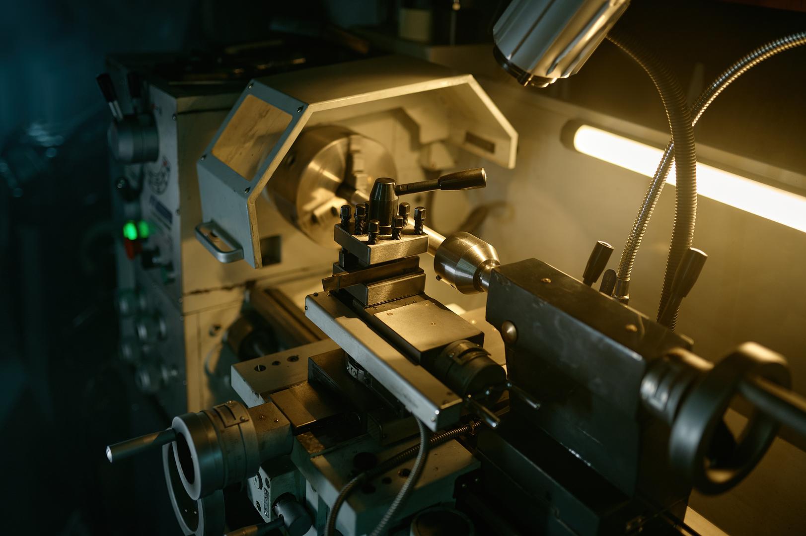 Manual engine lathe lit by a work lamp