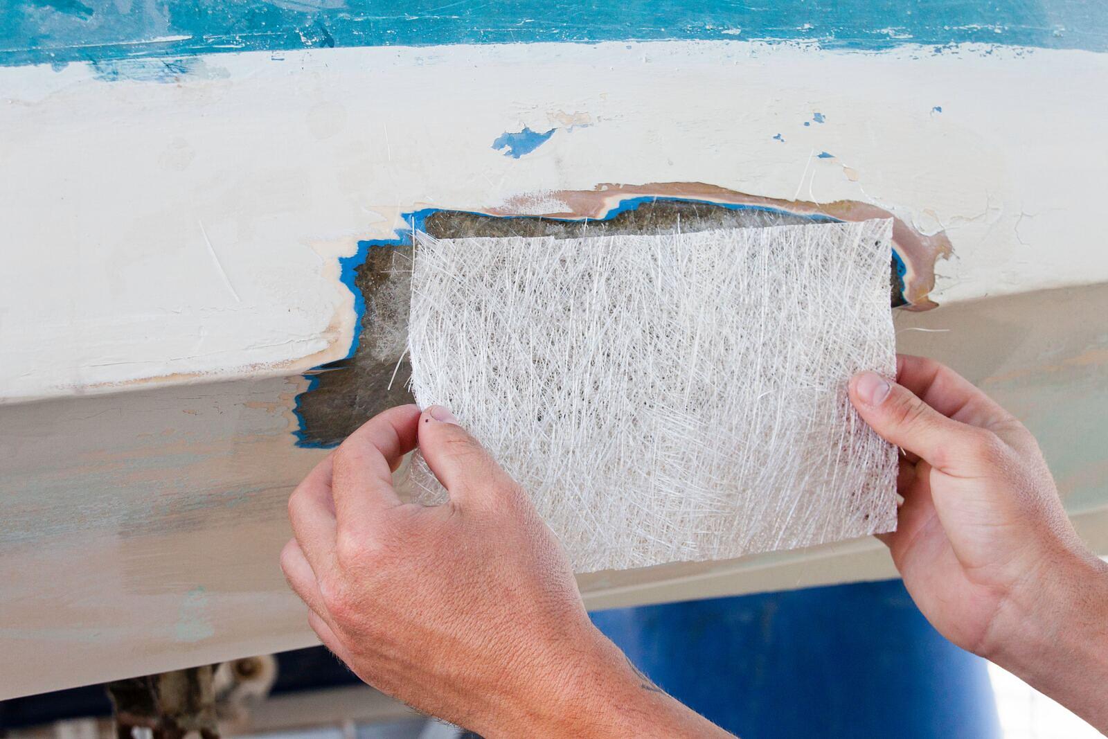 Fiberglass and gelcoat repair being performed on a boat hull