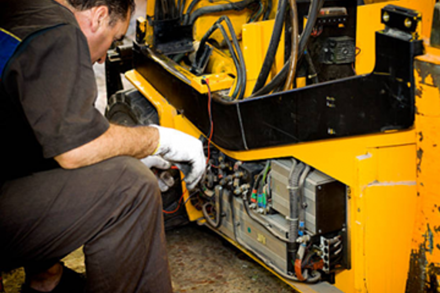 Technician performing preventive maintenance on a forklift