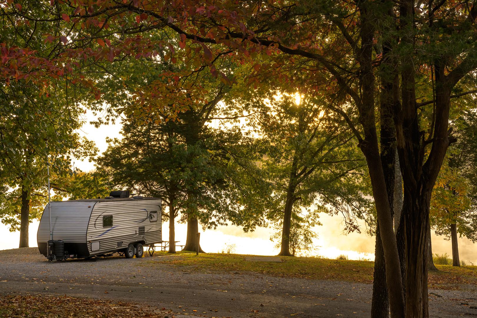 Travel trailer parked at an Ohio campground at golden hour