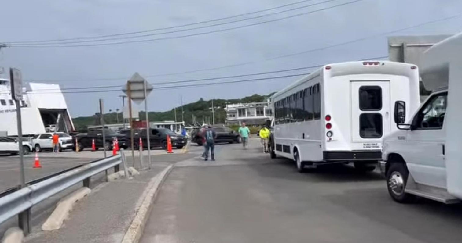 Three shuttle buses lined up at a ferry terminal for delivery by Best Buses For Sale