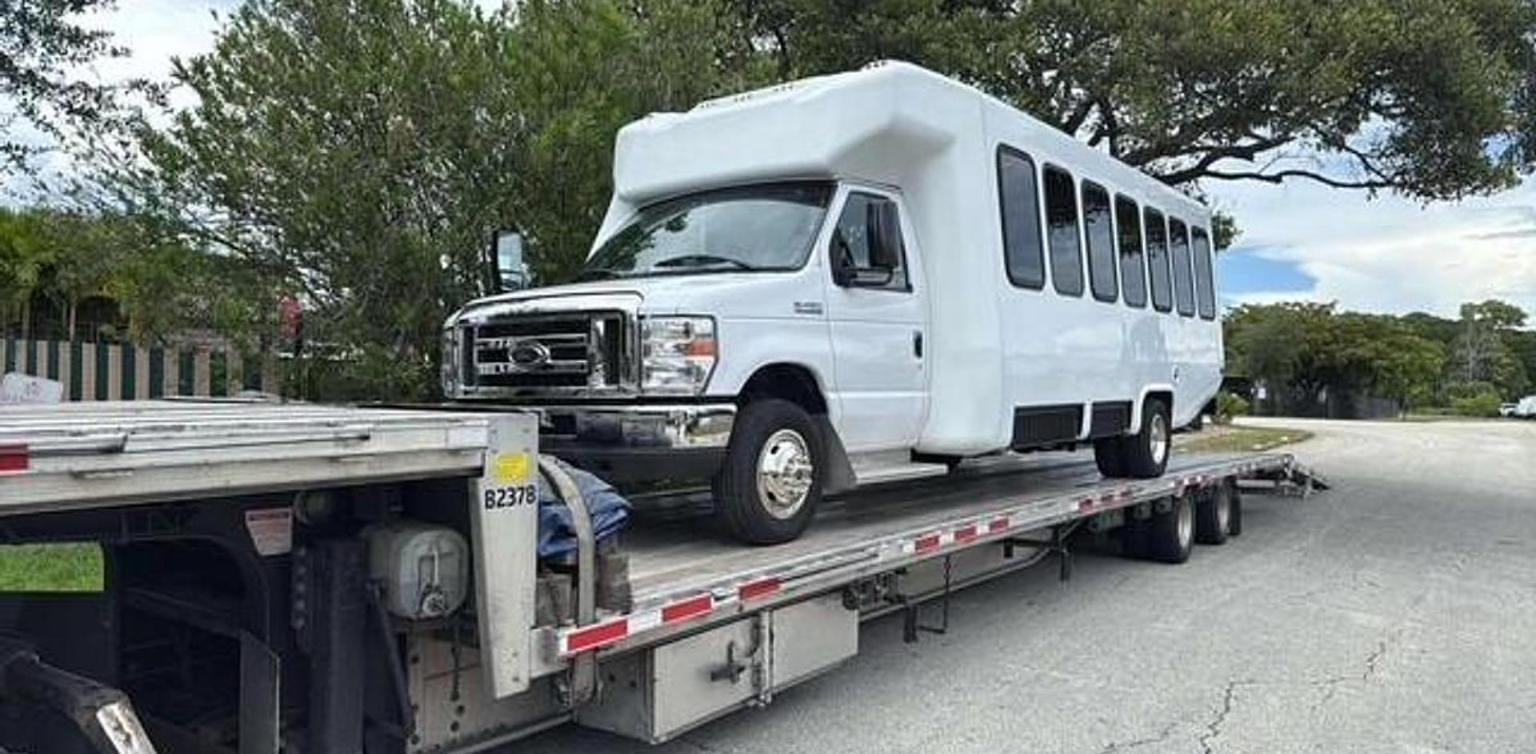 Reconditioned shuttle bus on a transport trailer, ready to ship to an international buyer