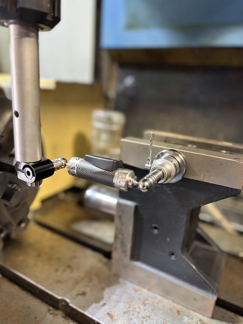 Ball bar mounted between the spindle and machine table during a test