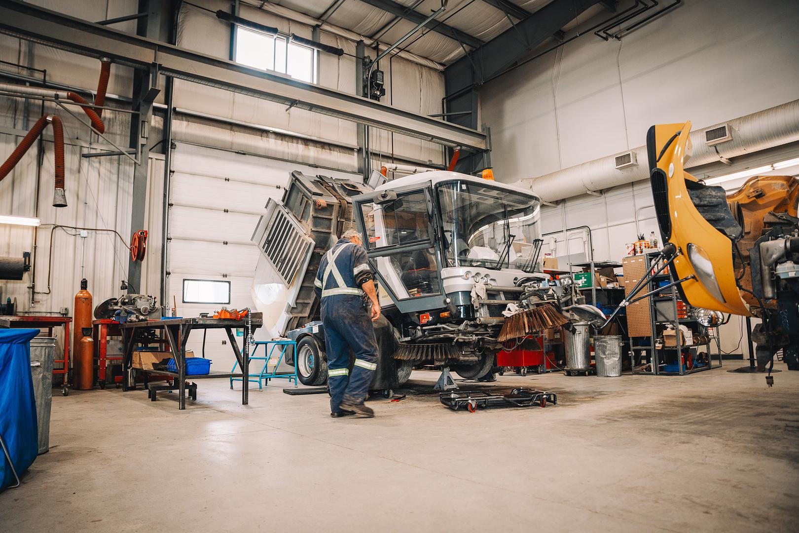 Wide view of the Motion Machinery shop with a street sweeper opened up for inspection