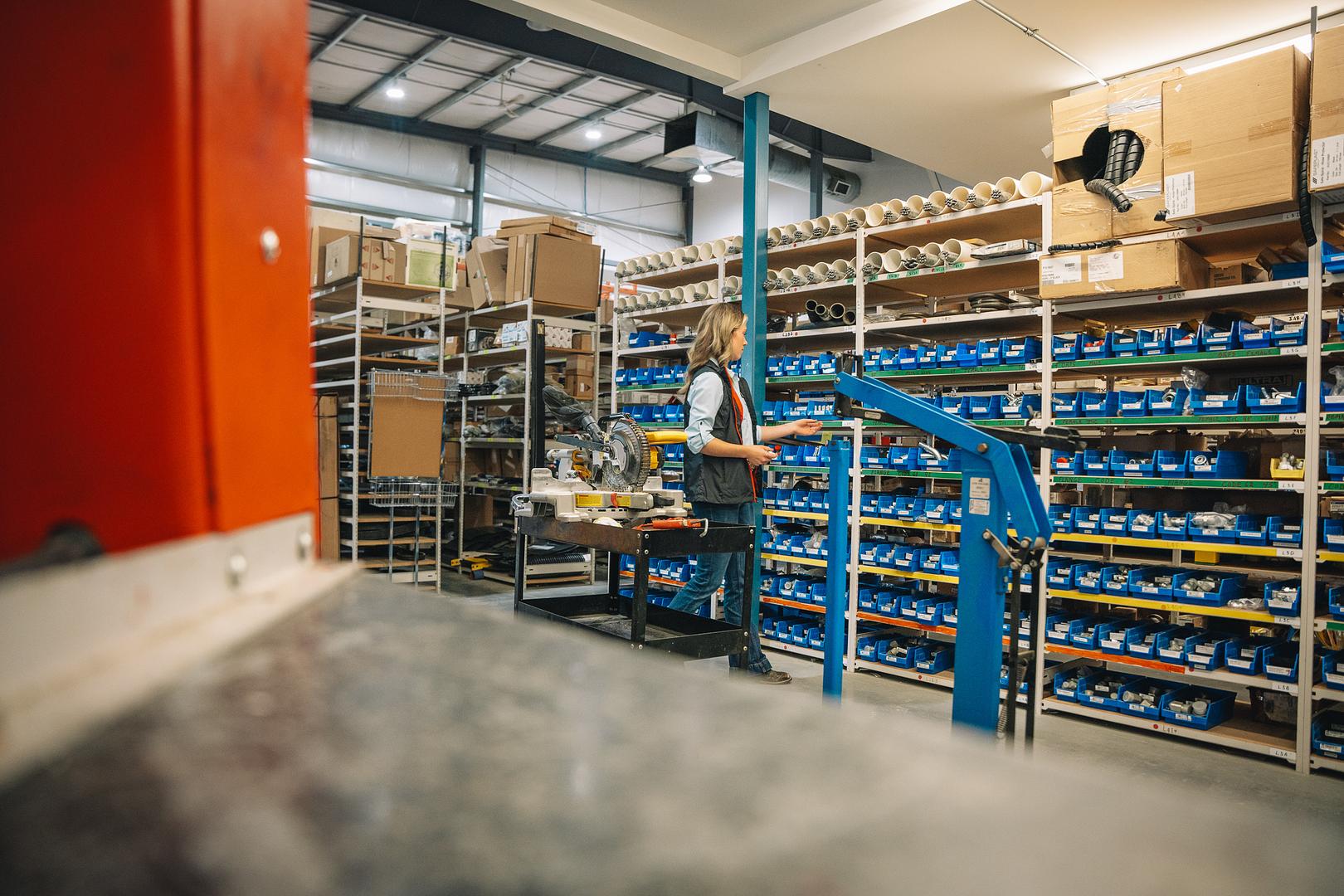 Stocked parts bins running the length of the Motion Machinery warehouse aisle