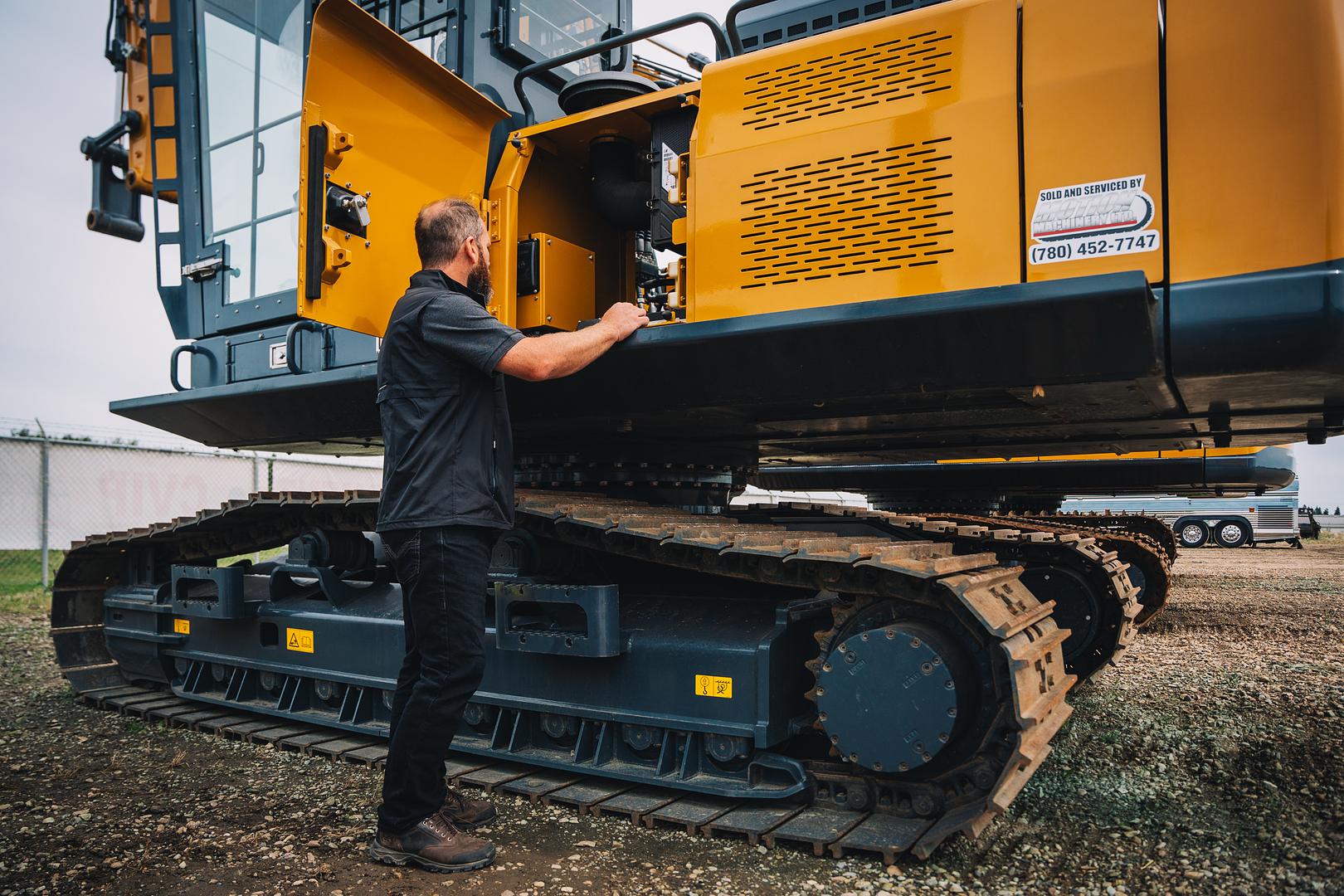 Excavator carrying the sold and serviced by Motion Machinery decal on the yard in Stony Plain