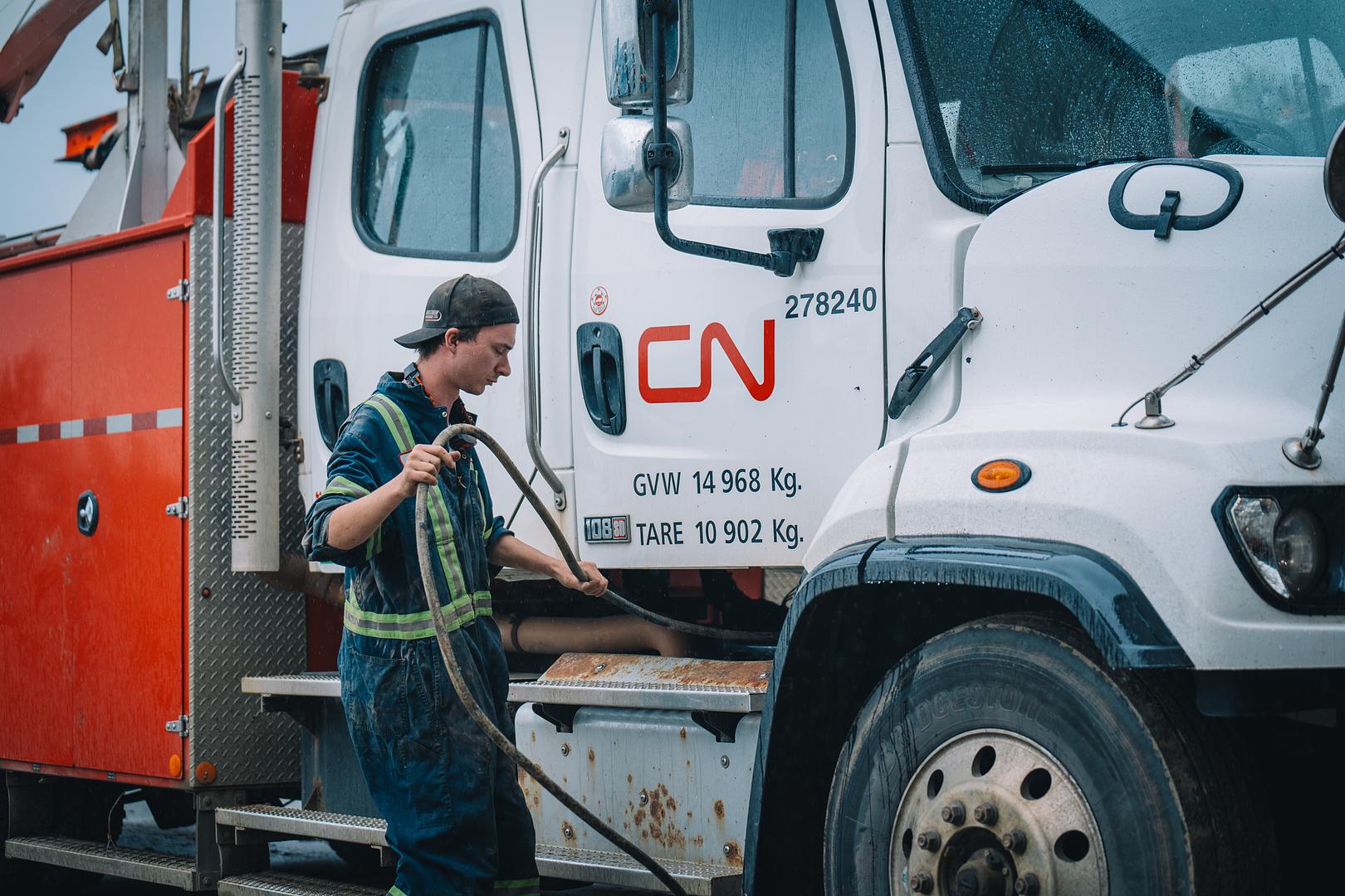 Motion Machinery technician servicing a fleet truck on location in wet weather