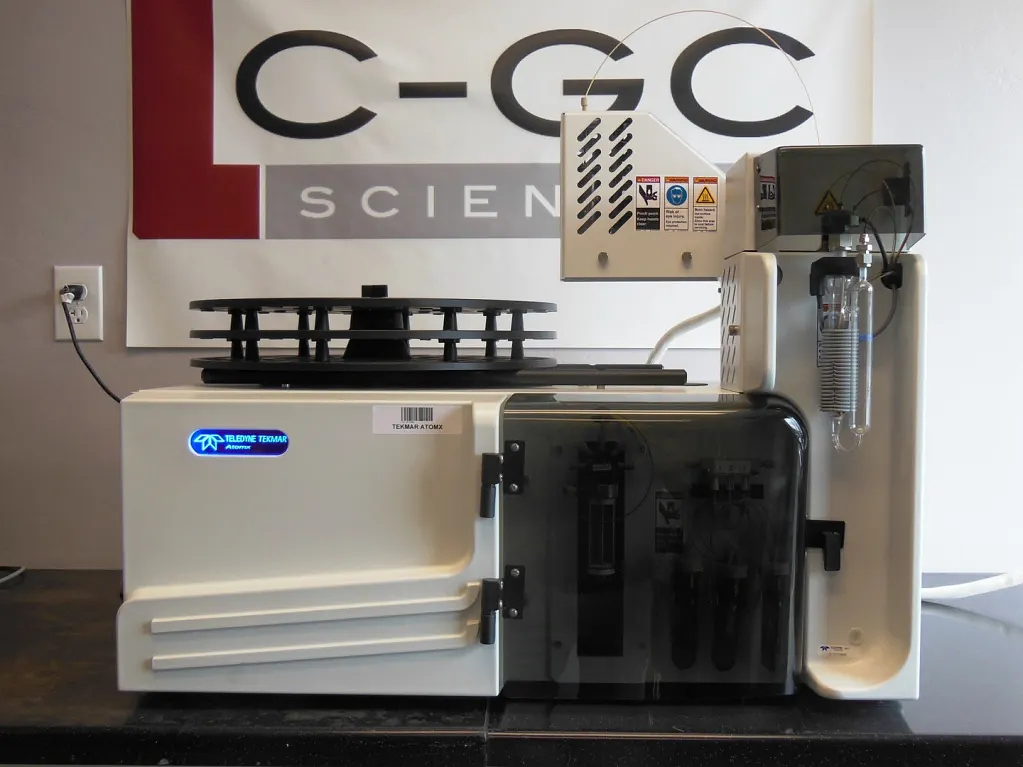 LC-GC Scientific technician working on a Teledyne Tekmar autosampler in front of the LC-GC Scientific banner