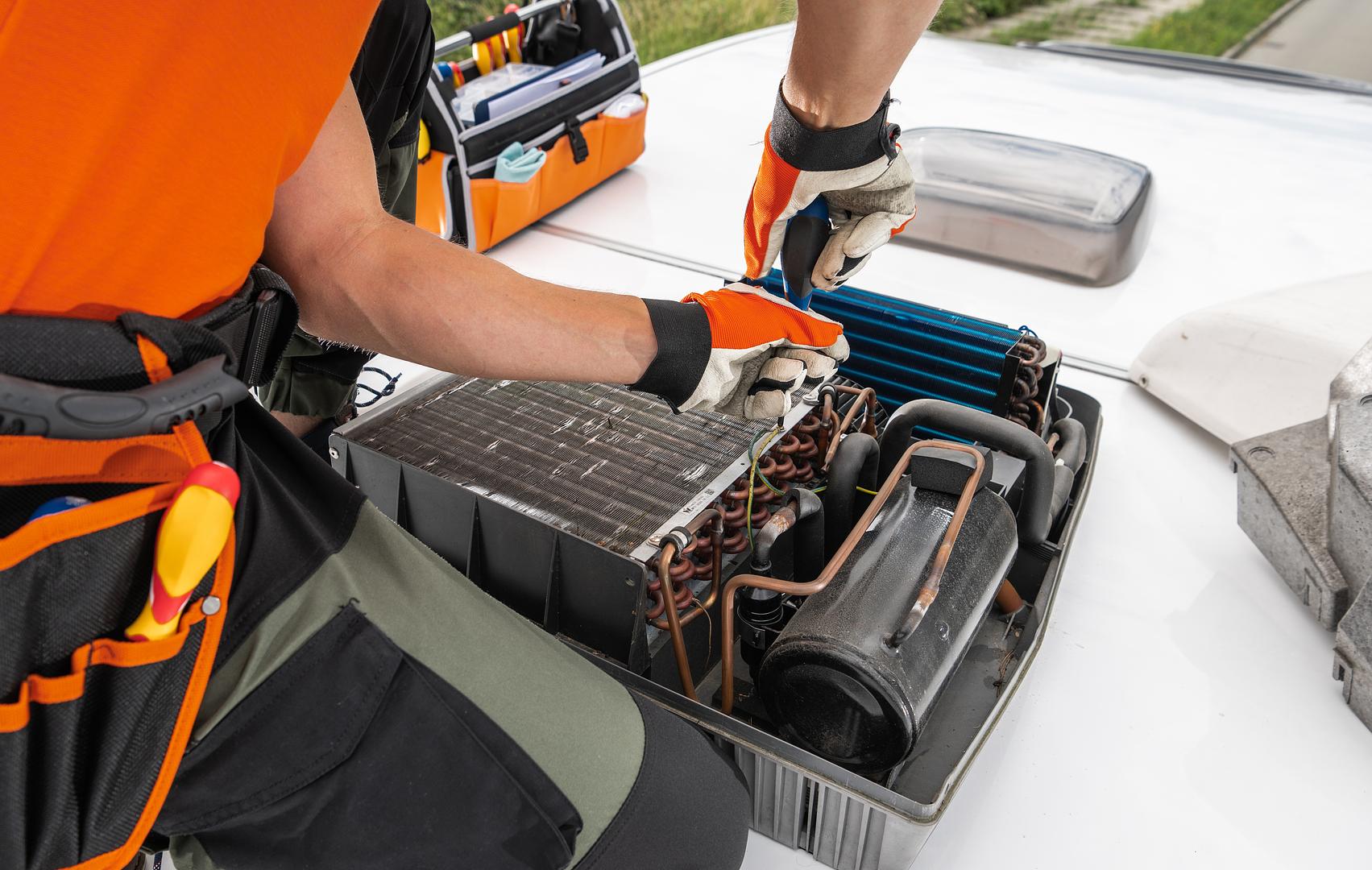 Technician servicing an RV air conditioner or appliance at Mattas Marine and RV