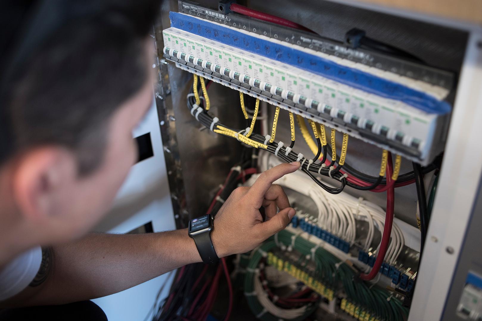 Technician repairing an RV electrical or plumbing system at Mattas Marine and RV