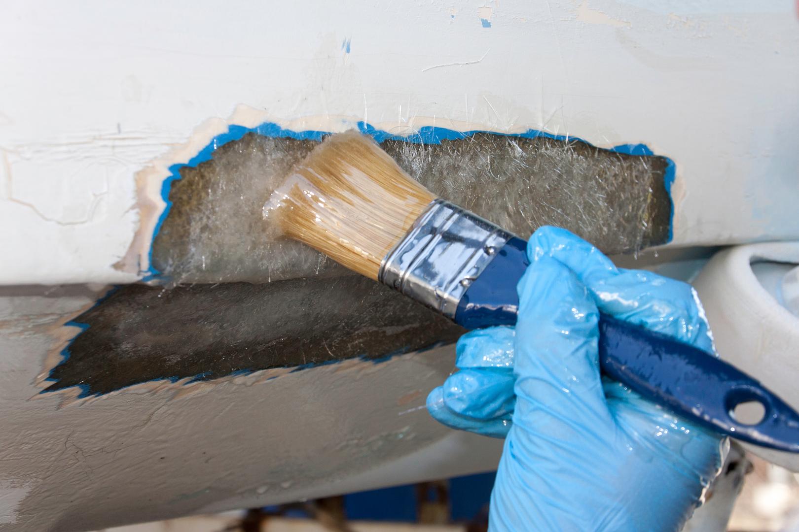 A technician working on a boat hull fiberglass repair